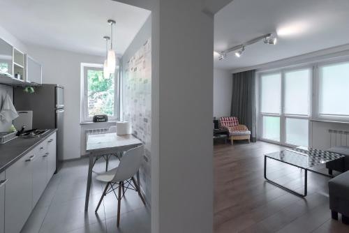 a kitchen and living room with a table and chairs at Art Apartament in Bielsko-Biała