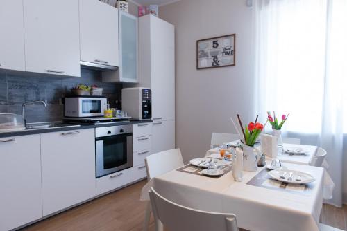 kuchnia z białym stołem z krzesłami i białym blatem w obiekcie B&B Le City w mieście Montesilvano
