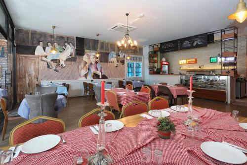 a restaurant with tables and chairs with red tablecloths at New Balturk Hotel Izmit in Kocaeli