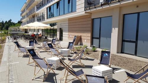 a group of chairs sitting in front of a building at Blue Marine Mielno in Mielno