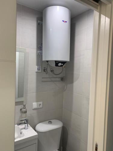a white bathroom with a toilet and a sink at ALOJAMIENTO CERRO DEL CABEZO in Andújar