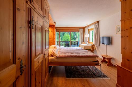 a bedroom with a bed and a window at Chesa La Furia in Pontresina