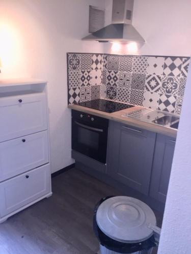 une petite cuisine avec un évier et une cuisinière dans l'établissement Maison à l'Amélie Plage, 300 mètres de la plage/mer, à Soulac-sur-Mer