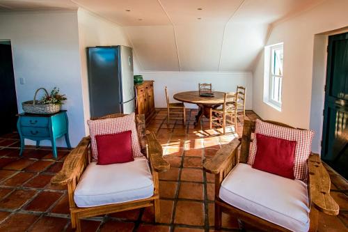 a living room with a table and chairs and a kitchen at Oudewerfskloof Olive Farm in Stilbaai