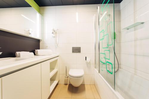 a bathroom with a toilet and a glass shower at harry's home Zürich-Wallisellen in Wallisellen