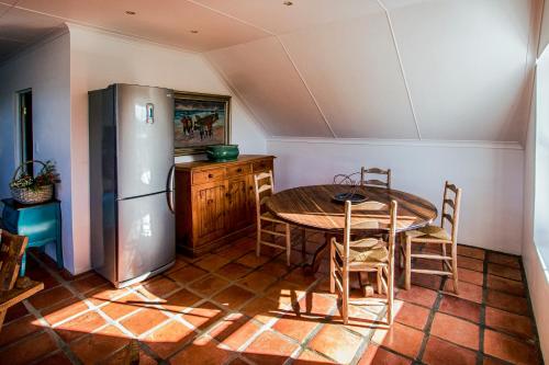 a kitchen with a table and a refrigerator at Oudewerfskloof Olive Farm in Stilbaai