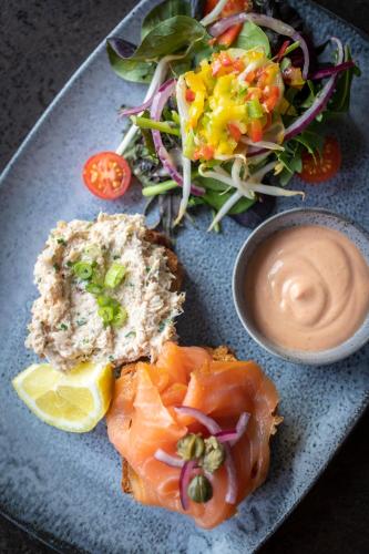 a plate of food with salmon and a salad and dip at Dingle Skellig Hotel in Dingle