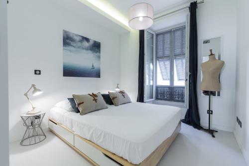 um quarto branco com uma cama e uma janela em DALPOZZO HYPER CENTRE PROCHE MER em Nice