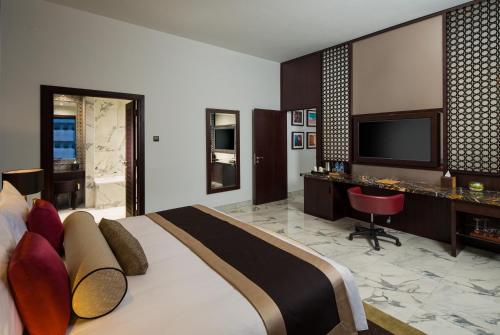 a bedroom with a bed and a desk and a television at Millennium Place Dubai Marina in Dubai