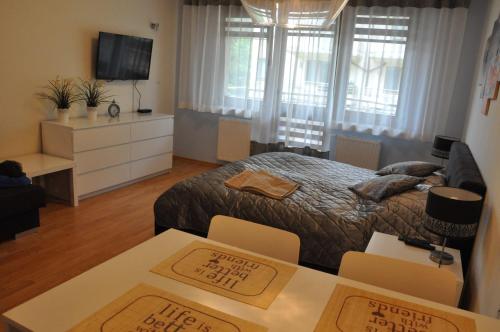 シフィノウイシチェにあるApartament Motylのベッドルーム1室(ベッド1台、テーブル2台、テレビ付)