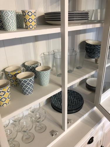 un meuble de cuisine rempli de assiettes, de bols et de verres dans l'établissement Very quiet 2-room apartment - Old Port, Town center, à La Rochelle