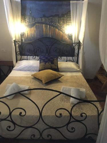 a bedroom with a bed with a wrought iron headboard at B&B Ginevra in Pisa