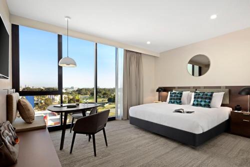 a hotel room with a large bed and a large window at Quest Innaloo in Perth