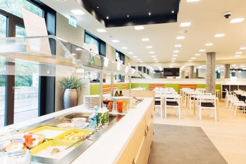 a restaurant with a buffet line with tables and chairs at harry's home Zürich-Wallisellen in Wallisellen
