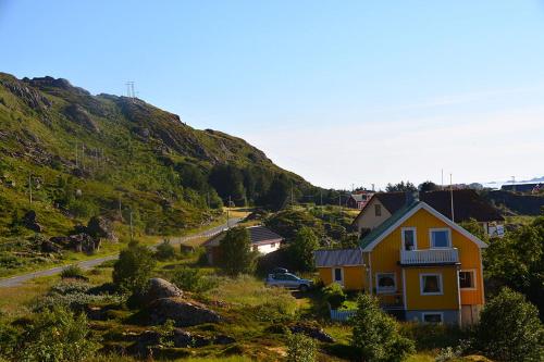 a yellow house on the side of a mountain at Edvinstua in Pettvik