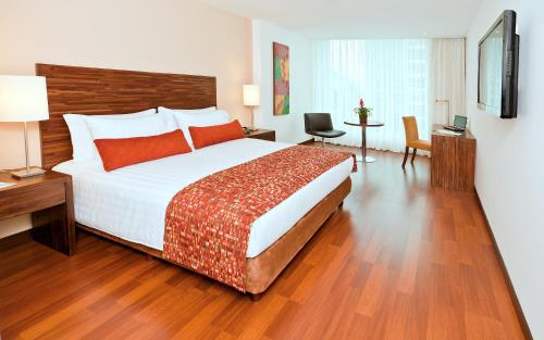 a hotel room with a large bed and a desk at Hotel Estelar Calle 100 in Bogotá
