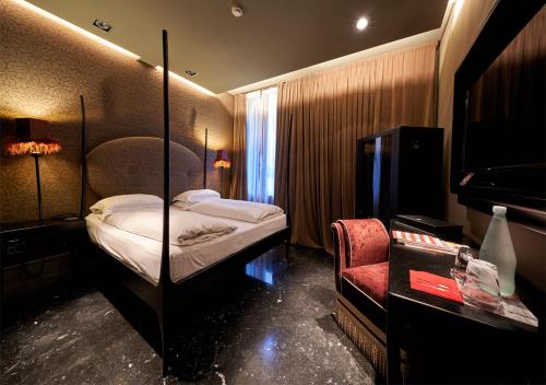a hotel room with a bed and a chair at Hotel Palazzo Barbarigo Sul Canal Grande in Venice