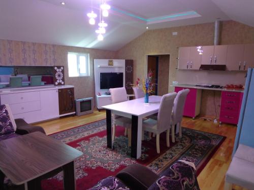 uma cozinha e sala de jantar com mesa e cadeiras em Tubram S Ailəvi Qonaq Evi em Sheki