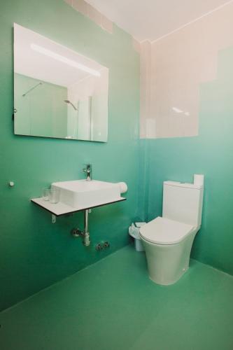 a bathroom with a toilet and a sink and a mirror at SubUp Hostel in Cabo de Palos