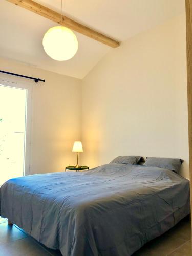une chambre avec un grand lit et une lampe dans l'établissement Chez Georges - Maison 2 - Les Gîtes du Verdon, à Esparron-de-Verdon