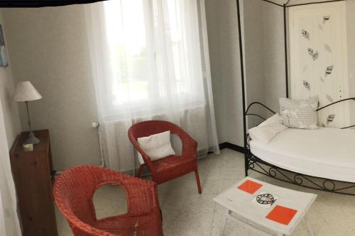 Cette chambre comprend un lit, une chaise et une table. dans l'établissement le Jardin d'Odette, à Yèvres-le-Petit