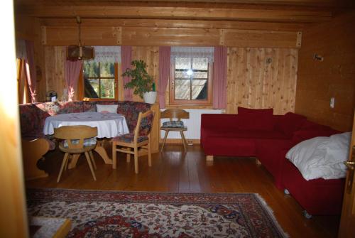 sala de estar con sofá rojo y mesa en Bauernhof Hatzlhof en Schöder