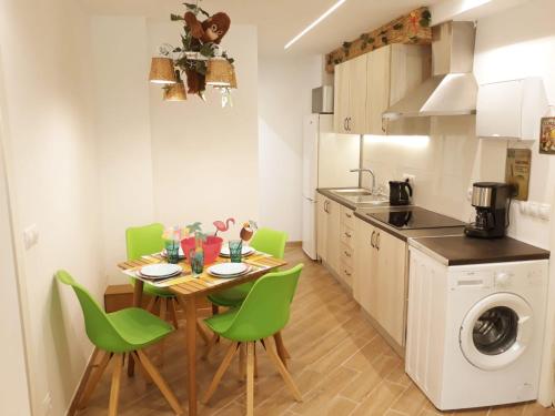 małą kuchnię ze stołem i zielonymi krzesłami w obiekcie Wonder Nerja Paraiso Apartamento w mieście Nerja