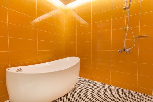 a toilet in a bathroom with an orange wall at Six Star Motel-Taoyuan in Taoyuan