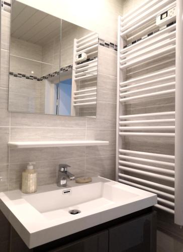 une salle de bain avec un lavabo blanc et un miroir dans l'établissement Beautifully Bright Apartment in Old Town Saint-Tropez, à Saint-Tropez