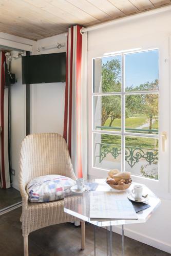 a room with a table and a chair and a window at Le Clos Du GALION - Ile de Ré in Saint-Martin-de-Ré
