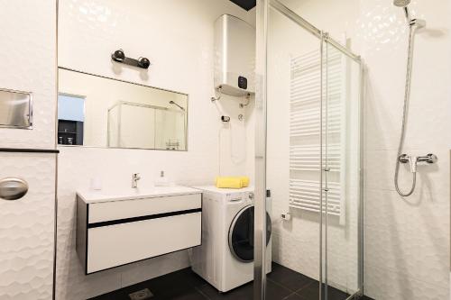 uma casa de banho com uma máquina de lavar roupa e um lavatório em Apartment Zeus Znjan Split em Split