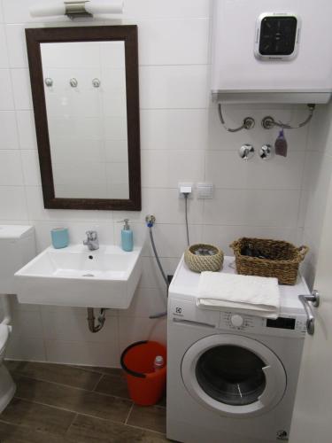 a bathroom with a washing machine and a sink at Holiday Home Isabella in Vis