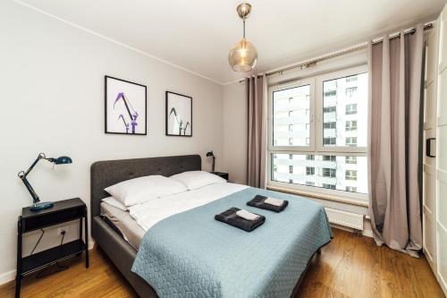 1 dormitorio con cama y ventana grande en PoBookowane Stocznia Apartments Gdańsk en Gdansk