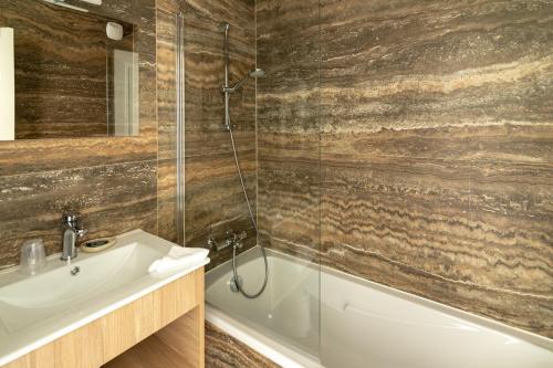 a bathroom with a shower and a sink and a tub at Le Clos Du GALION - Ile de Ré in Saint-Martin-de-Ré