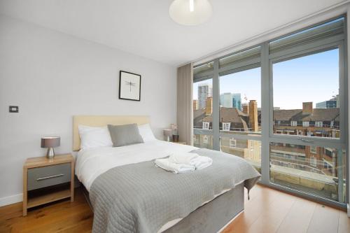 1 dormitorio con cama y ventana grande en 2 Bed Executive Penthouse near Liverpool Street FREE WIFI by City Stay Aparts London, en Londres