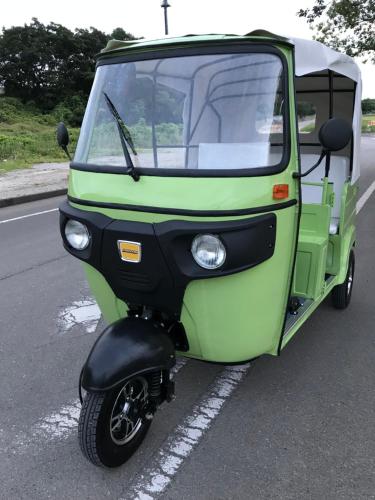 a small green vehicle parked in a parking lot at Tuktuk House in Kawagoe