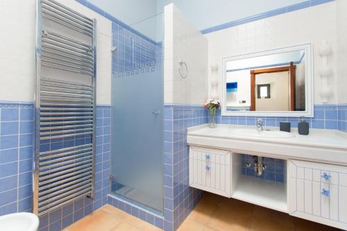 a blue tiled bathroom with a sink and a shower at Casa En Moscari in Moscari