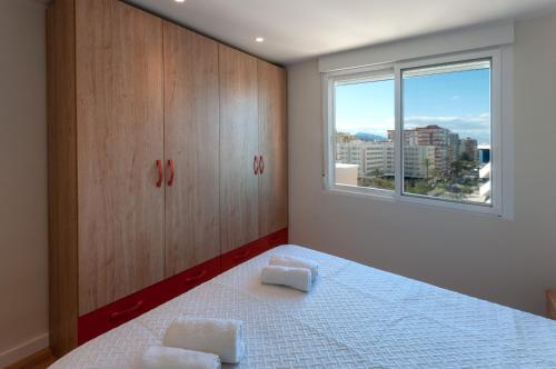 a bedroom with a bed and a window at Torres Del Mar in Playa de Gandia