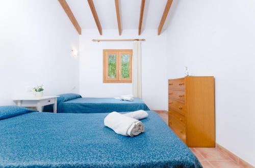1 dormitorio con 2 camas con sábanas azules y vestidor en Perú, en Son Serra de Marina