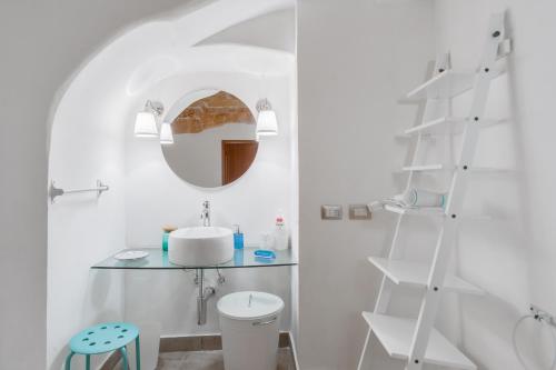 een witte badkamer met een wastafel en een spiegel bij CasaMia in Alliste