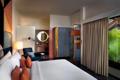 a hotel room with a bed and a chair at Viroth's Villa in Siem Reap