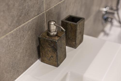 ミラノにあるSUITE 11 NEAR DUOMOの- バスルームのシンクに座った金属製石鹸2台