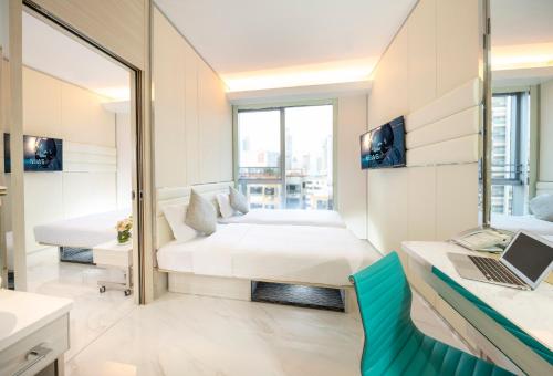 a hotel room with a bed and a laptop on a desk at iclub Mong Kok Hotel in Hong Kong
