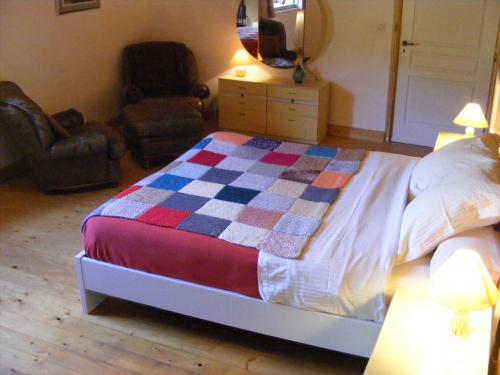 a bedroom with a bed with a checkered quilt on it at Les Grandes Fontaines in La Longine