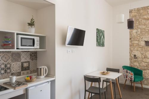 a kitchen with a table and chairs and a microwave at Archinuè in Siracusa