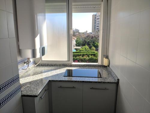 baño con lavabo y ventana en Apartamento Las Adelfas, en Jerez de la Frontera
