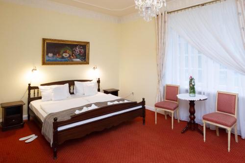 um quarto com uma cama, 2 cadeiras e uma mesa em Hotel Dwór Sójki em Sójki