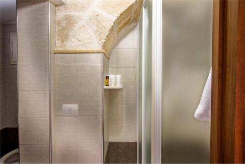 y baño con ducha y puerta de cristal. en Casa Narciso en Polignano a Mare