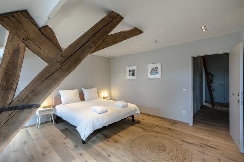 una camera con letto bianco e travi in legno di Logement Den Beer a Meerhout