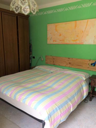 a bed in a bedroom with a green wall at Acero Rosso in San Colombano